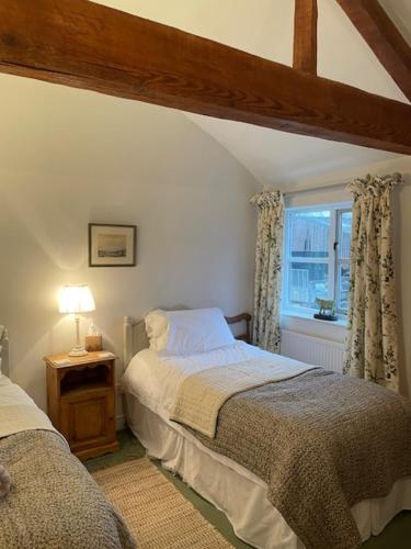 a bedroom with two beds and a window at Joyce’s Barn in Normanton