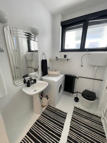 Baño blanco con lavabo y espejo en Apartment Mirochka, en Belgrado