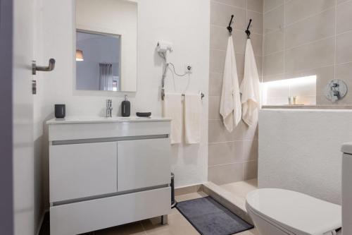 a white bathroom with a sink and a toilet at Country Pool House 27 in Abrantes
