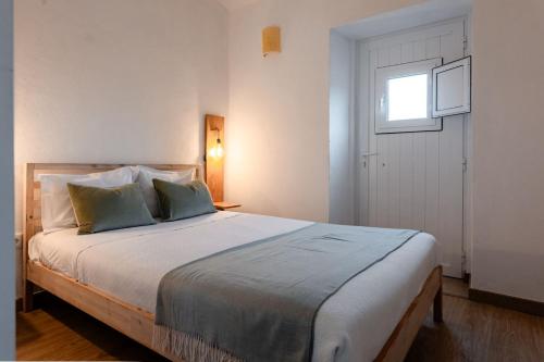 a bedroom with a large bed with a window at Country Pool House 27 in Abrantes