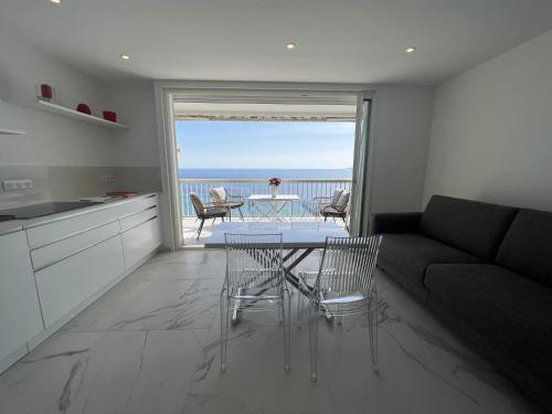 - un salon avec un canapé et une table avec des chaises dans l'établissement Sea View Bellamare next Palais Festival, à Cannes