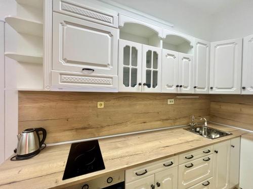 a kitchen with white cabinets and a sink at Flower house 10 in Sofia