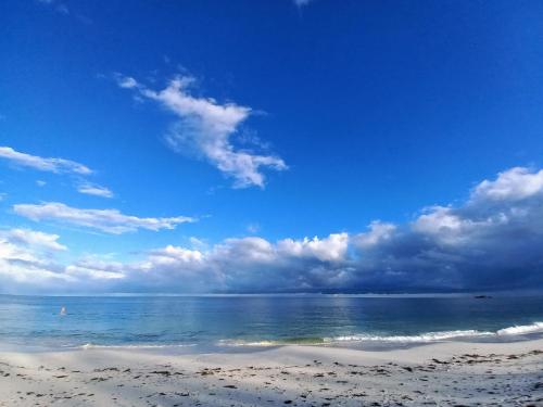 a beach with the ocean and a cloudy sky at Watamu Beach Cottages in Watamu