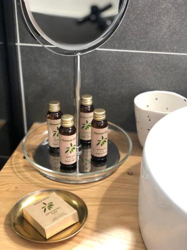 - un plateau avec cinq bocaux sur une table et un miroir dans l'établissement La bohème place aux herbes, à Uzès