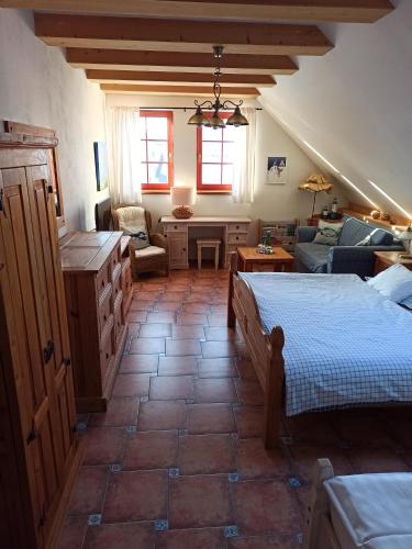 a bedroom with two beds and a living room at Penzion Rozmarýn in Vsetín