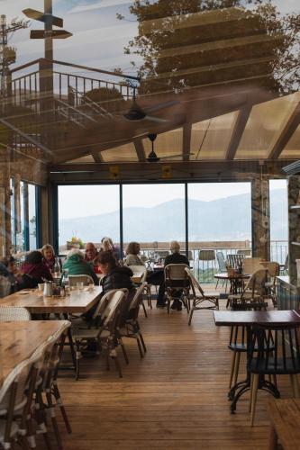 people sitting at tables in a restaurant with a view at Rom Farm by Glow - חוות רום in Kammon