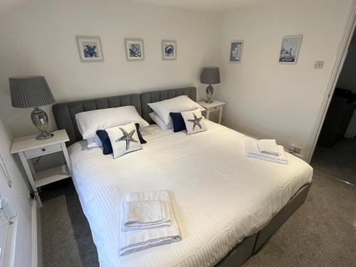 a bedroom with two beds with white sheets and pillows at The Sail Loft in Cowes