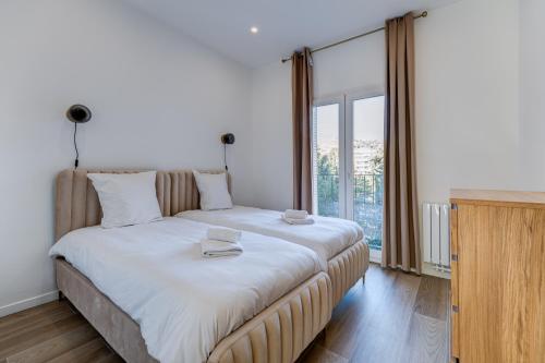 un grand lit dans une chambre avec une grande fenêtre dans l'établissement Les Grands Cèdres - Wifi, AC, Parking, à Nice