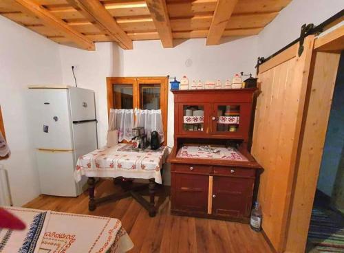 a kitchen with a refrigerator and a table in it at Casa Bunicii in Topliţa