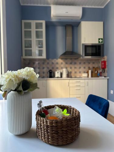 a vase of flowers and a basket on a table at Aveiro History Apartments in Aveiro