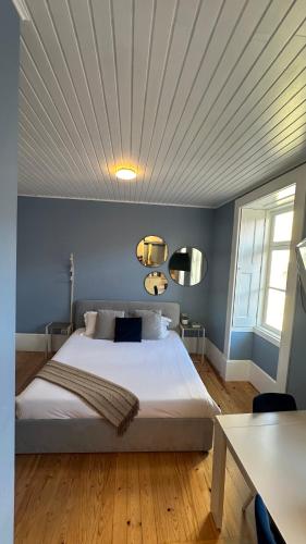 a bedroom with a large bed with blue walls at Aveiro History Apartments in Aveiro