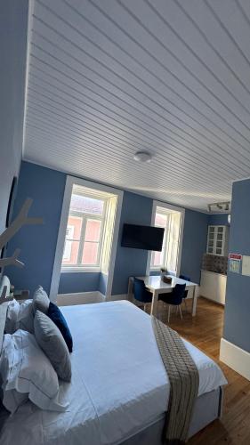 a bedroom with a large bed with a blue wall at Aveiro History Apartments in Aveiro
