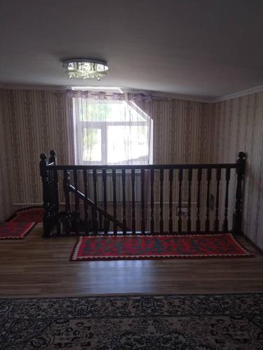 une chambre avec lit bébé dans une chambre avec fenêtre dans l'établissement Myrza, à Kasymbek
