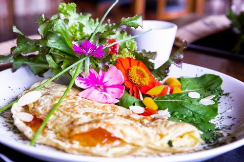 a plate of food with a salad with flowers on it at Pousada Cavaleiro dos Pireneus in Pirenópolis