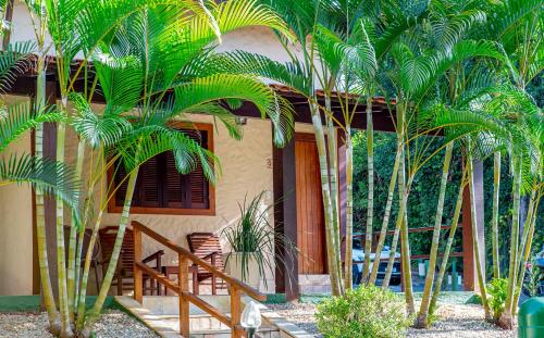 a house with palm trees in front of it at Pousada Cavaleiro dos Pireneus in Pirenópolis