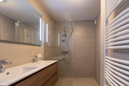 een badkamer met een wastafel en een douche bij Appartementencomplex Juliana 46 in De Koog