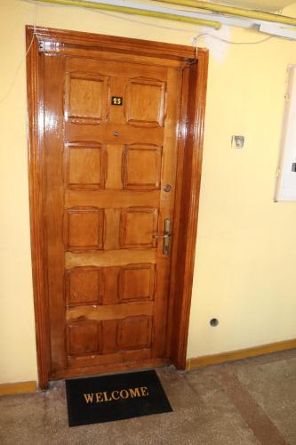 a wooden door with a welcome sign in front of it at Propriete no.6 - close to university, hospital and downtown in Iaşi