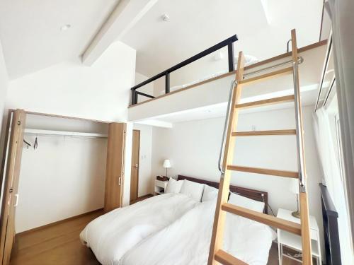 1 dormitorio con litera y escalera en Niseko White Villas1, en Niseko