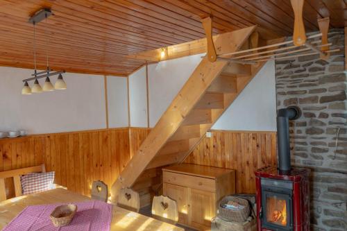 a wooden staircase in a room with a stove at Chalupa Na Sklepě in Velké Karlovice