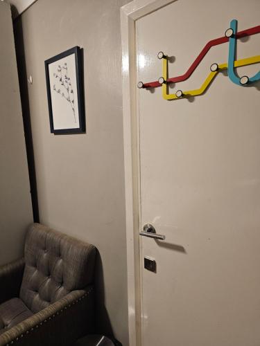 a door in a room with a couch and a chair at Umbrella Properties London Excel in London