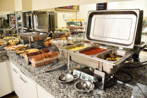 a buffet line with many different types of food at Hotel Casa Nova in Várzea Grande