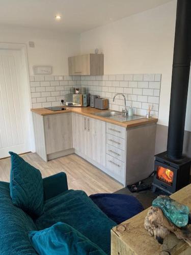a living room with a kitchen with a stove at Lakeside Eco Lodge- 'Heron' in Bishampton