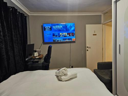 a hotel room with a bed and a flat screen tv at Umbrella Properties London Excel in London