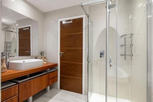 La salle de bains est pourvue d'une douche en verre et d'un lavabo. dans l'établissement Dovehouse, à Londres