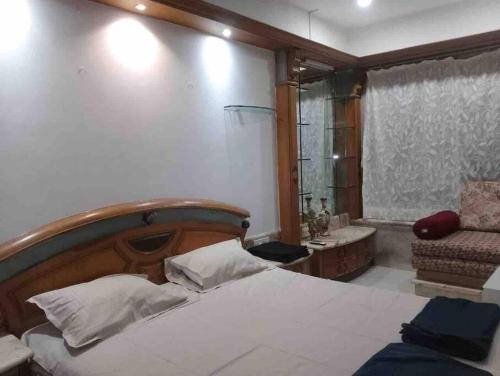 een slaapkamer met een bed, een stoel en een bad bij Luxury Studio with bathtub in Mumbai
