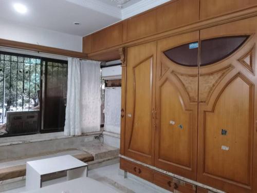 a room with a wooden door and a window at Luxury Studio with bathtub in Mumbai