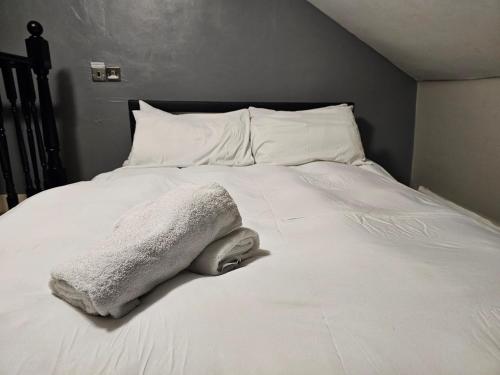 a white blanket laying on top of a bed at Umbrella Properties London Excel in London
