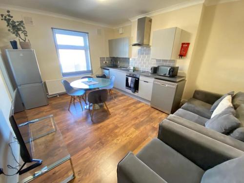 a living room with a couch and a table at 2 Bedroom Apartment 2 Min Walk to Station - longer stays available in Gravesend
