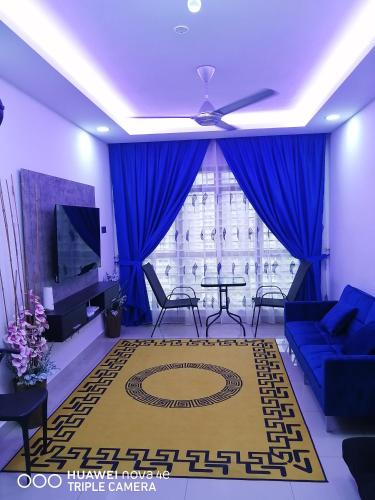 un salon avec un canapé bleu et une télévision dans l'établissement KASTURI GUEST HOUSE PUTRAJAYA, à Putrajaya