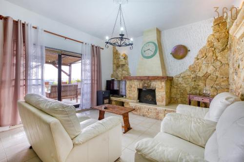 Stunning 4BR Villa with Huge Terrace in Kappara by 360 Estates في إيل جزيرا: غرفة معيشة مع كنبتين بيضاء ومدفأة