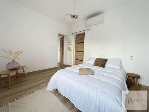 une chambre blanche avec un grand lit et une table dans l'établissement Appartement place Turenne, à Dunkerque