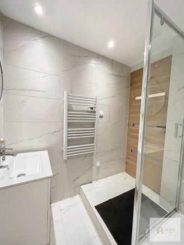 une salle de bain blanche avec une douche et un lavabo dans l'établissement Appartement place Turenne, à Dunkerque