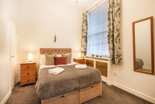 1 dormitorio con cama, ventana y espejo en York Suite on the historic Shambles, sleeps 6, en York