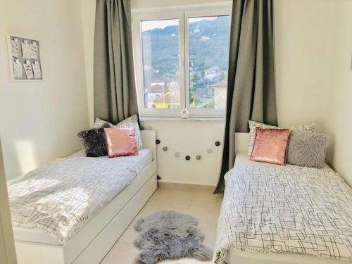 ein kleines Schlafzimmer mit 2 Betten und einem Fenster in der Unterkunft Apartment Aurora in Opatija