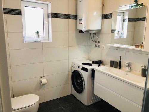 ein Badezimmer mit einer Waschmaschine und einem Waschbecken in der Unterkunft Apartment Aurora in Opatija