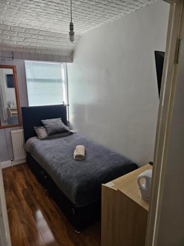 - une chambre avec un lit et une couette bleue dans l'établissement Comfortable single room in Family home, Heathrow airport, à Northolt