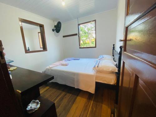 małą sypialnię z łóżkiem i lustrem w obiekcie Ferrari Casa Nostra w mieście Santa Teresa