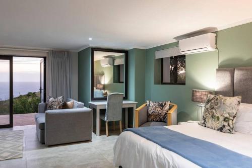 een hotelkamer met een bed, een bureau en stoelen bij Pezula Beachfront Splendour - 5 bedroom in Knysna