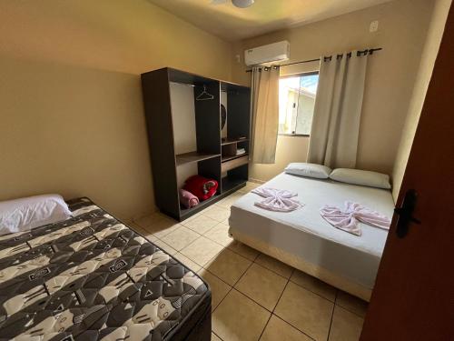 a bedroom with two beds and a window at Apartamento aconchegante no centro de Toledo in Toledo