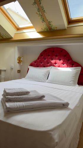 a white bed with a red headboard and white pillows at L'échelle Rouge in Cannes