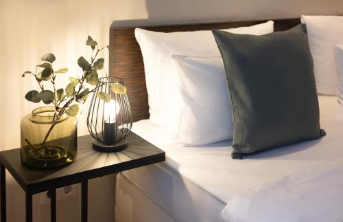 a bed with two pillows and a lamp on a table at Paragon Apartments in Frankfurt/Main