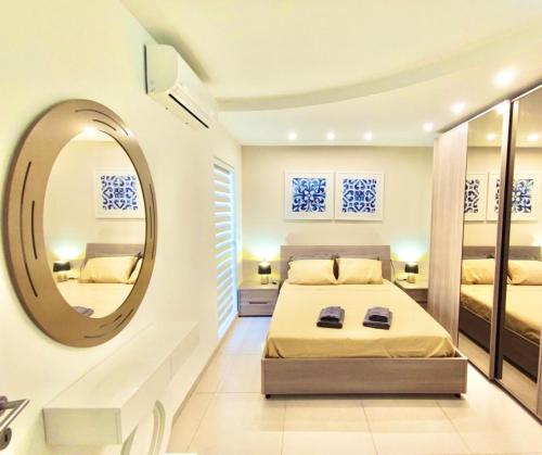 een slaapkamer met 2 bedden en een spiegel bij The Papillon Penthouse in Santa Vennera