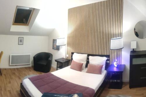 um quarto de hotel com uma cama e uma cadeira em HÉBERGEMENT au LOGIS em Sougé-le-Ganelon