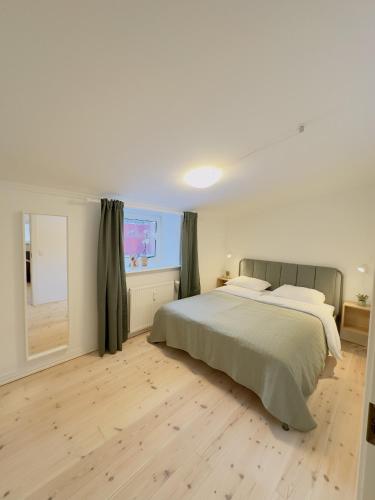 a bedroom with a large bed and a window at aday - Holiday Apartment in the heart of Frederikshavn in Frederikshavn