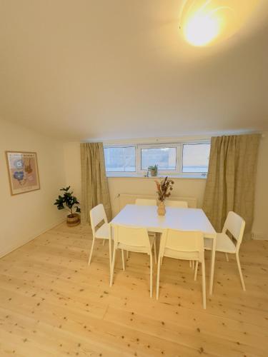 a dining room with a white table and chairs at aday - Holiday Apartment in the heart of Frederikshavn in Frederikshavn