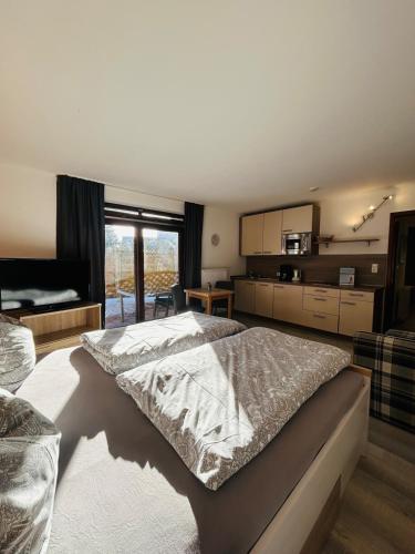 1 Schlafzimmer mit einem großen Bett und einer Küche in der Unterkunft StrandLiebeDuhnen in Cuxhaven
